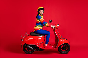 Fototapeta na wymiar Photo portrait of shocked girl riding retro scooter isolated on vivid red colored background