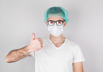 American surgeon doctor man over gray background looking and showing okay sign.