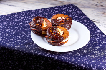 Three yummy homemade chocolate covered marshmallow crackers on white plate on a purple napkin