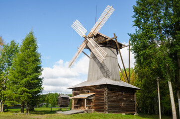 Fototapeta na wymiar Windmill with wooden wings. Dutch type mill