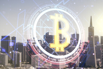 Double exposure of creative Bitcoin symbol hologram on San Francisco city skyscrapers background. Cryptocurrency concept