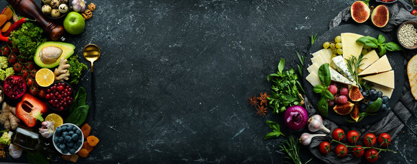 Big set of vegetables, fruits, berries and food on a black stone background. Free space for text. Top view.