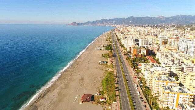 Panorama view of the beautiful town Mahmutlar, Taurus mountains and beach overwashed by Mediterranean sea. Antalya Province, Turkey. Drone footage, 4k.