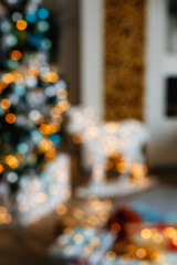 blurry Christmas tree is out of focus with orange, yellow and red lights in a bright room. Holiday backdrop with space for text