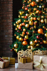 Selective focus. Artificial Christmas tree decorated with shiny gold balls and ornaments. Copy space
