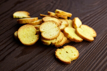 Bruschette chips, dry slices of baked bread, beer snacks scattered on wooden table