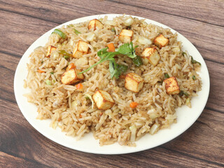 Healthy and tasty Paneer fried rice made of rice, mixed veggies and paneer, served in bowl over a...