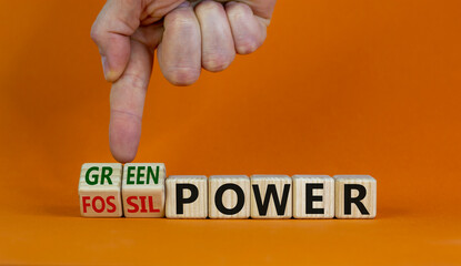 Grom fossil to green power. Male hand turns cubes and changes the words 'fossil power' to 'green...