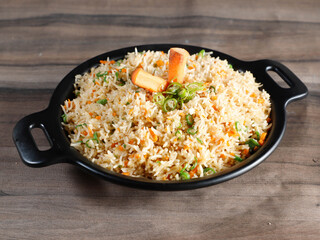 Healthy and tasty veg fried rice made of mixed veggies served in bowl over a rustic wooden background, Indo chinese, Indian cuisine, selective focus