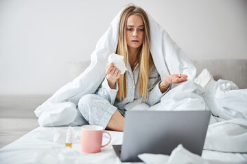 Sick young woman having online consultation with doctor at home
