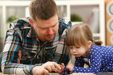Fototapeta premium Cute little girl on floor carpet with dad use cellphone calling mom portrait. Life style apps social web network wireless ip telephony concept