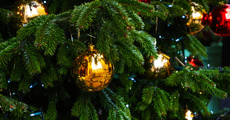 Winter christmas background with fir branches and Christmas balls. Decorated Christmas tree on blurred background.