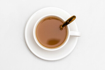 White cup of tea and herbal beverage, Top view, golden spoon, isolated white background