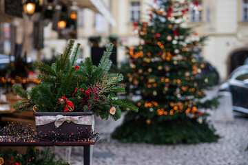 Decorated Christmas tree, blurred background. Christmas decoration balls hanging on pine branches christmas tree garland and ornaments with abstract background with copy space.