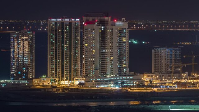 Aerial skyline of Abu Dhabi city centre from above night timelapse with illuminated skyscrapers.