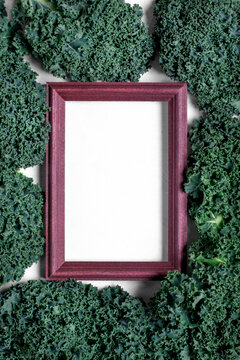 Kale around the picture frame with copy space on white. Top view. Food background