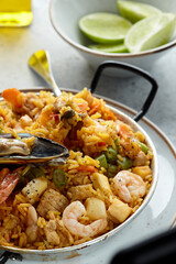 Closeup Classic valencian paella from rice with seafood and vegetables - traditional dish of spanish cuisine and sangría