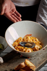 Chef proudly presenting spanish paella valenciana - spanish cuisine