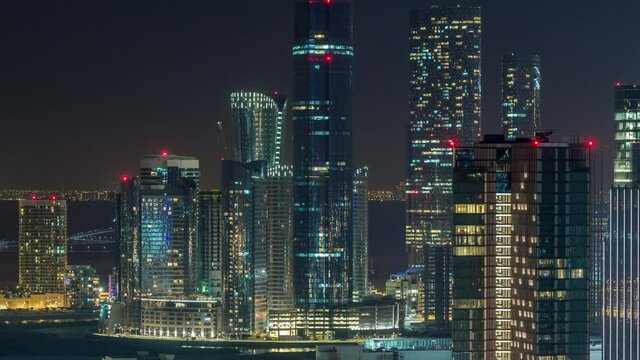 Aerial skyline of Abu Dhabi city centre from above night timelapse with illuminated skyscrapers