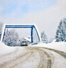 Austria, after heavy snowfall a car drives carefully on a bridge