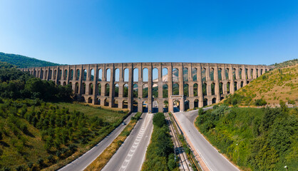 Aerial view panorama. The Aqueduct of Vanvitelli, Caroline. Valle di Maddaloni, near Caserta Italy. 17th century. Large stone structure for transporting water. Viaduct. - obrazy, fototapety, plakaty