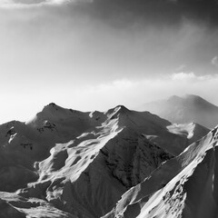 Obraz premium Black and white view on snowy sunlight mountains in early fog morning