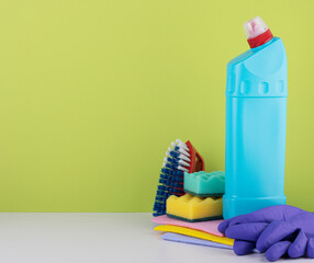 cleaning products on a green background with space for text