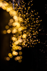 Goldene Lichtpunkte Bokeh auf einem schwarzen Hintergrund  mit einer goldenen Spiegelung.