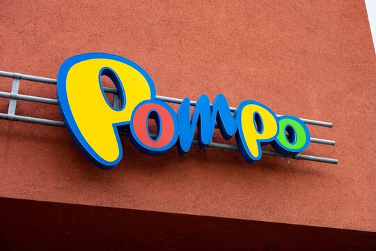 The logo of Pompo toy store above the shop at the red wall