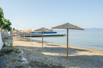Reed umbrellas on the beach of the island of Evia-Greece 