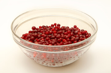 cranberries in a glass bowl on a white background