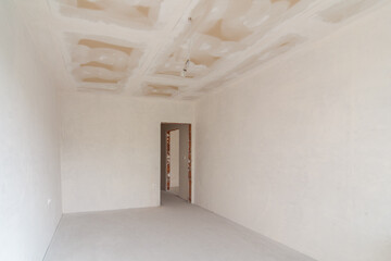 New empty room under construction. Plaster walls. New home. Concrete walls. Interior renovation.