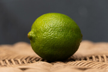 Angled Green Lime on a wicker table with a blue background