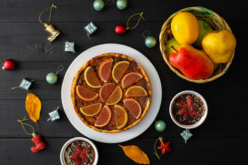 Pumpkin pie, sweet desserts and Christmas toys on a black background.
