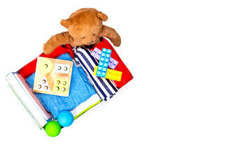 Donation box with baby kid toys, books, clothing for charity on white background. Top view