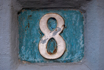 Old retro weathered cast iron plate with number 8 closeup
