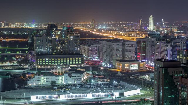 Aerial skyline of Abu Dhabi city centre from above night timelapse with illuminated skyscrapers with traffic on road
