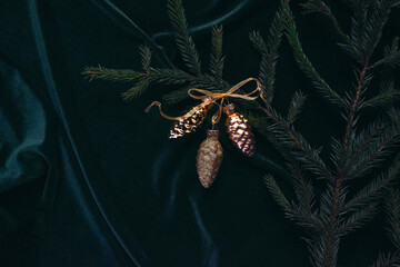 Christmas background. Spruce branches with toys of gold color on a dark velvet background