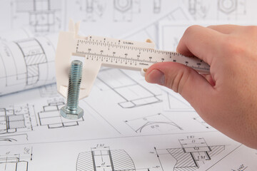 Measurement of bolt dimensions with an engineering caliper. Work of engineer.