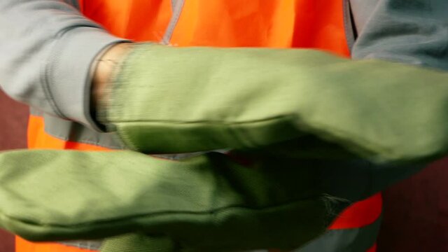 Close-up of a slinger worker gesturing with his hands to stop work. The builder shows the commands to the crane operator. Worker at a construction site. Selective focus, shallow depth of field