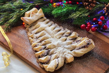 Puff pastry cookies in the shape of a Christmas tree on a wooden cutting Board . New year's holiday...