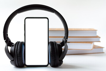 phone and headphones in the background of books. concept choice of technology or classics.