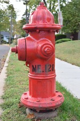 A Newly Installed Red Fire Hydrant Standing at a Sidewalk at a Community