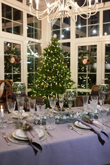 Home Christmas decoration interior late in night with light on xmas tree and gifts.