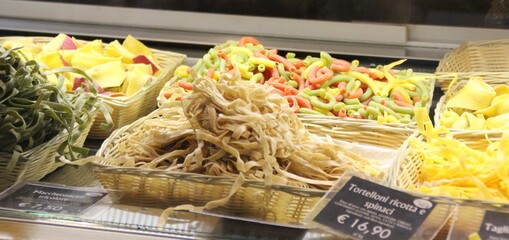 fresh pasta in various formats arranged in baskets behind the counter