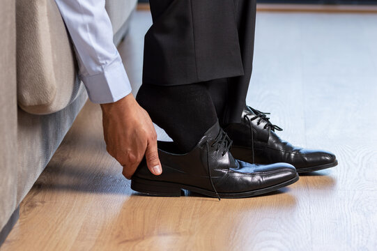 Businessman Taking Off Shoes After Work At Home