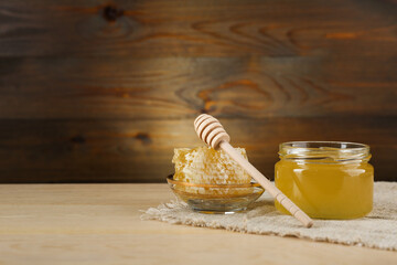Fototapeta na wymiar fresh honey in a jar on a wooden background