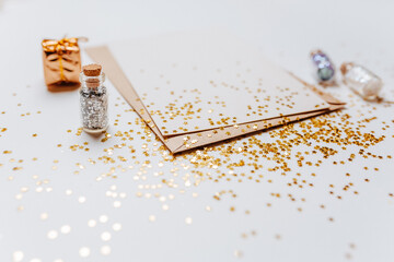 Blank note with envelope, gifts and gold glitter stars on white background