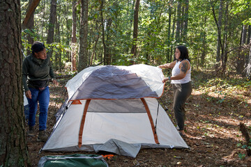 Friends setting up tent at campsite