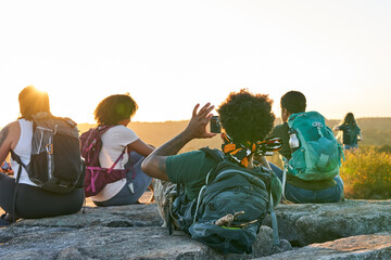 Friends enjoying weekend getaway on mountain top at sunset